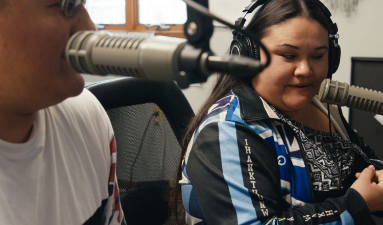 People talking into microphones for a radio show