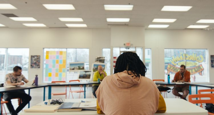 people sitting across a bright room from each other