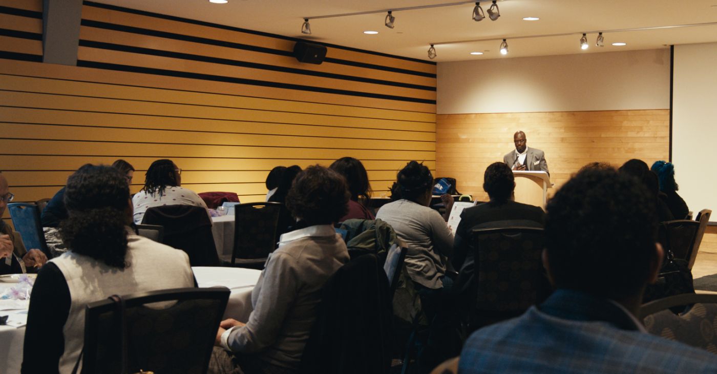 Man presenting to a crowd