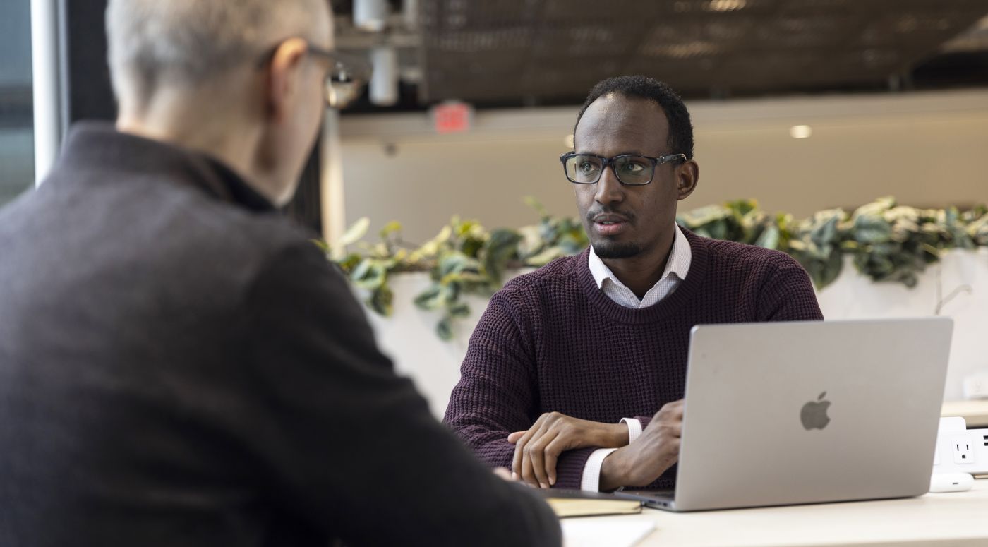 Mukhtar Ibrahim (BF’16) talking to a colleague