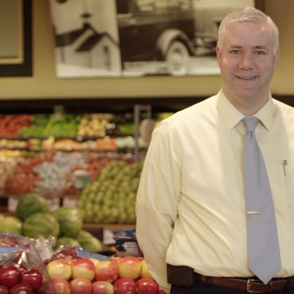 Man standing in front of produce at a grocery store