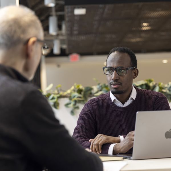 Mukhtar Ibrahim (BF’16) talking to a colleague