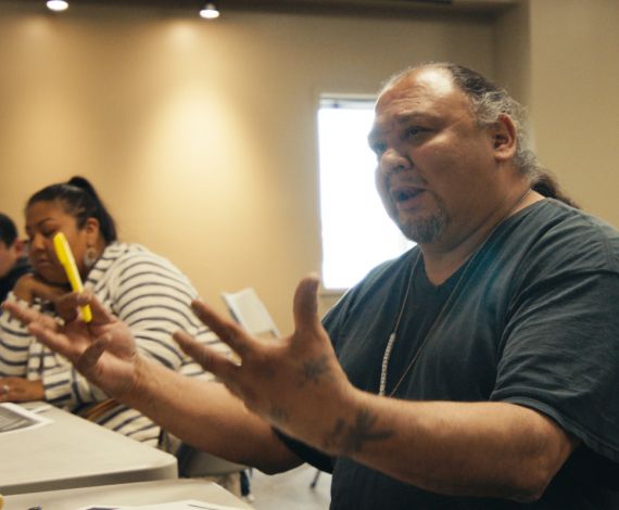 man speaking with outstretched hands