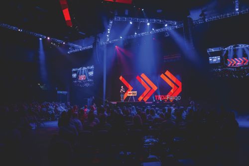 Emcee Greg Tehven welcomes more than 2,000 attendees to the 10th TEDxFargo event in Fargo, North Dakota.