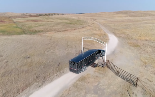 A truck driving through the entrance of Mustang Meadows.
