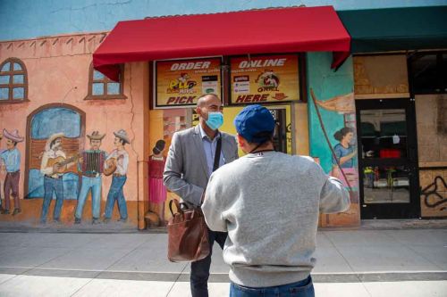 man speaks to another man on the street