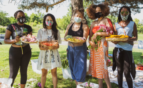 A group of young people holding baskets of flowers.