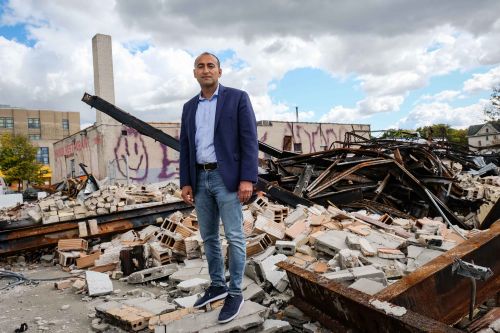 man stands on top of building ruble