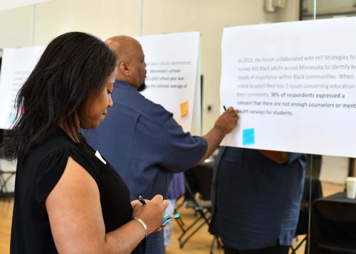 Woman writing on note at African American Leadership Forum (AALF) convenings