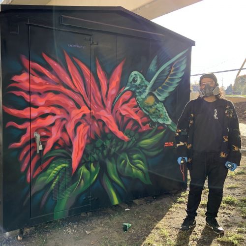 Andrés Guzmán in front of mural.